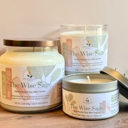 Three 'The Wise Sage' rosemary and sage candles of different sizes on a wooden surface with a neutral background.