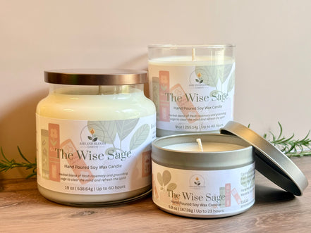 Three 'The Wise Sage' rosemary and sage candles of different sizes on a wooden surface with a neutral background.