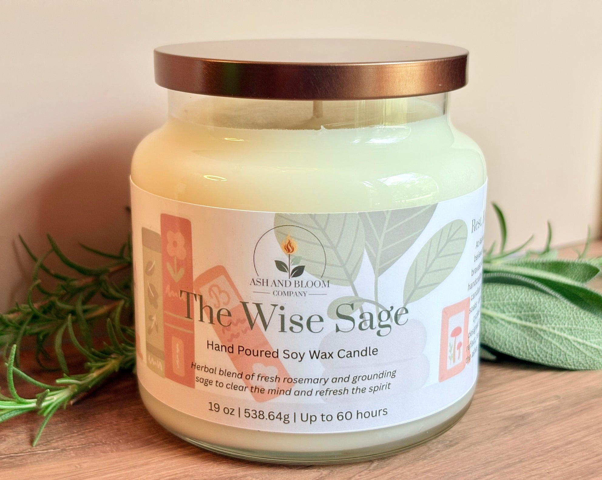 Jar of 'The Wise Sage' candle with a label on a wooden surface, surrounded by sage leaves.