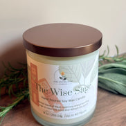Candle labeled 'The Wise Sage' on a wooden surface with a neutral background