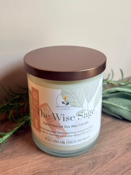 Candle labeled 'The Wise Sage' on a wooden surface with a neutral background