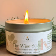 Candle in a tin labeled 'The Wise Sage' on a wooden surface with a blurred background