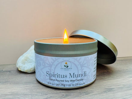 Nag champa scented candle in a tin labeled 'Spiritus Mundi' with a lit wick on a wooden surface.