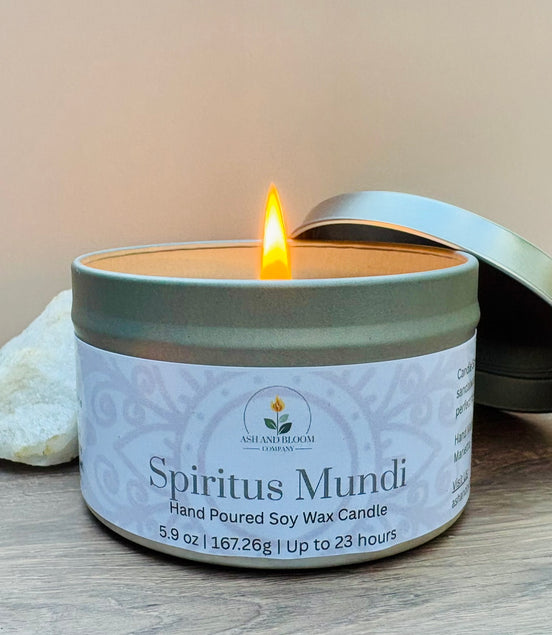 Nag champa scented candle in a tin labeled 'Spiritus Mundi' with a lit wick on a wooden surface.