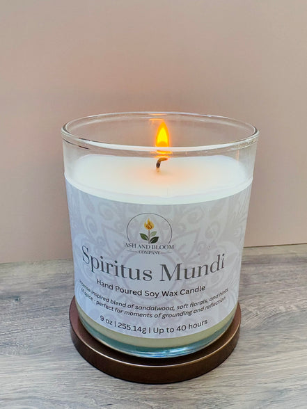 Nag champa candle labeled 'Spiritus Mundi' with a wooden coaster on a light wood surface.