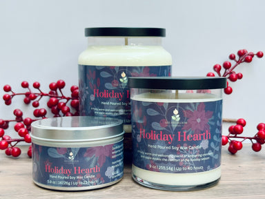 Three cranberry and apple 'Holiday Hearth' candles with red berries on a light background