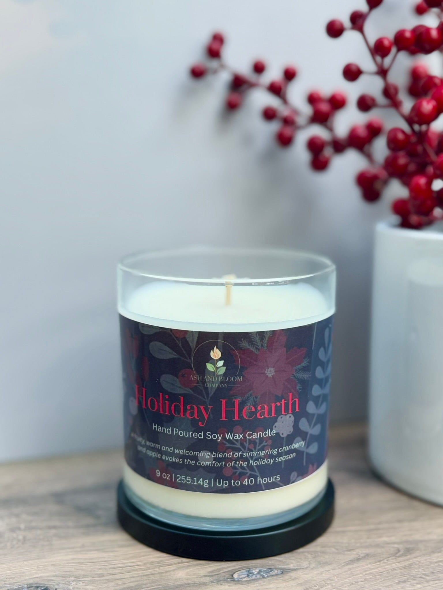 Candle labeled 'Holiday Hearth' with a decorative background of red berries.