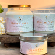 Three 'Rise and Shine' citrus and mint candles on a wooden stand with a soft background