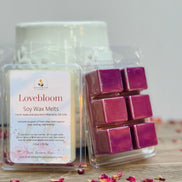 Lovebloom rose soy wax melts packaging with pinkish purple wax cubes on a wooden surface.