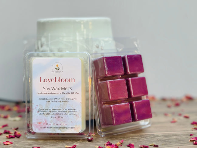 Lovebloom rose soy wax melts packaging with pinkish purple wax cubes on a wooden surface.