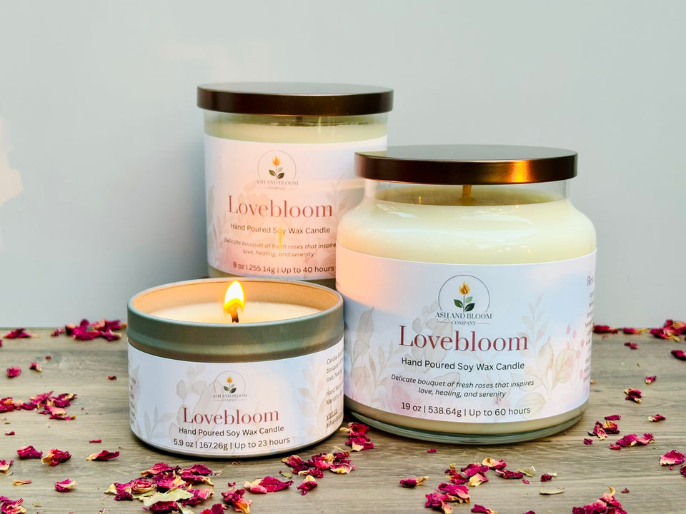 Lovebloom candles on a wooden surface with scattered rose petals.