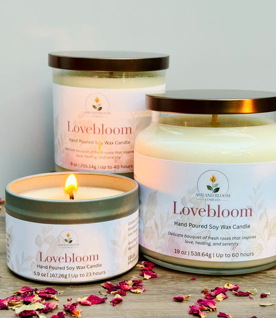 Lovebloom candles on a wooden surface with scattered rose petals.