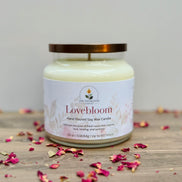 Lovebloom candle jar on a wooden surface with scattered dried flowers