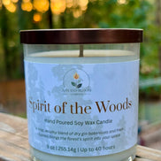 Candle labeled 'Spirit of the Woods' on a wooden surface with a blurred natural background