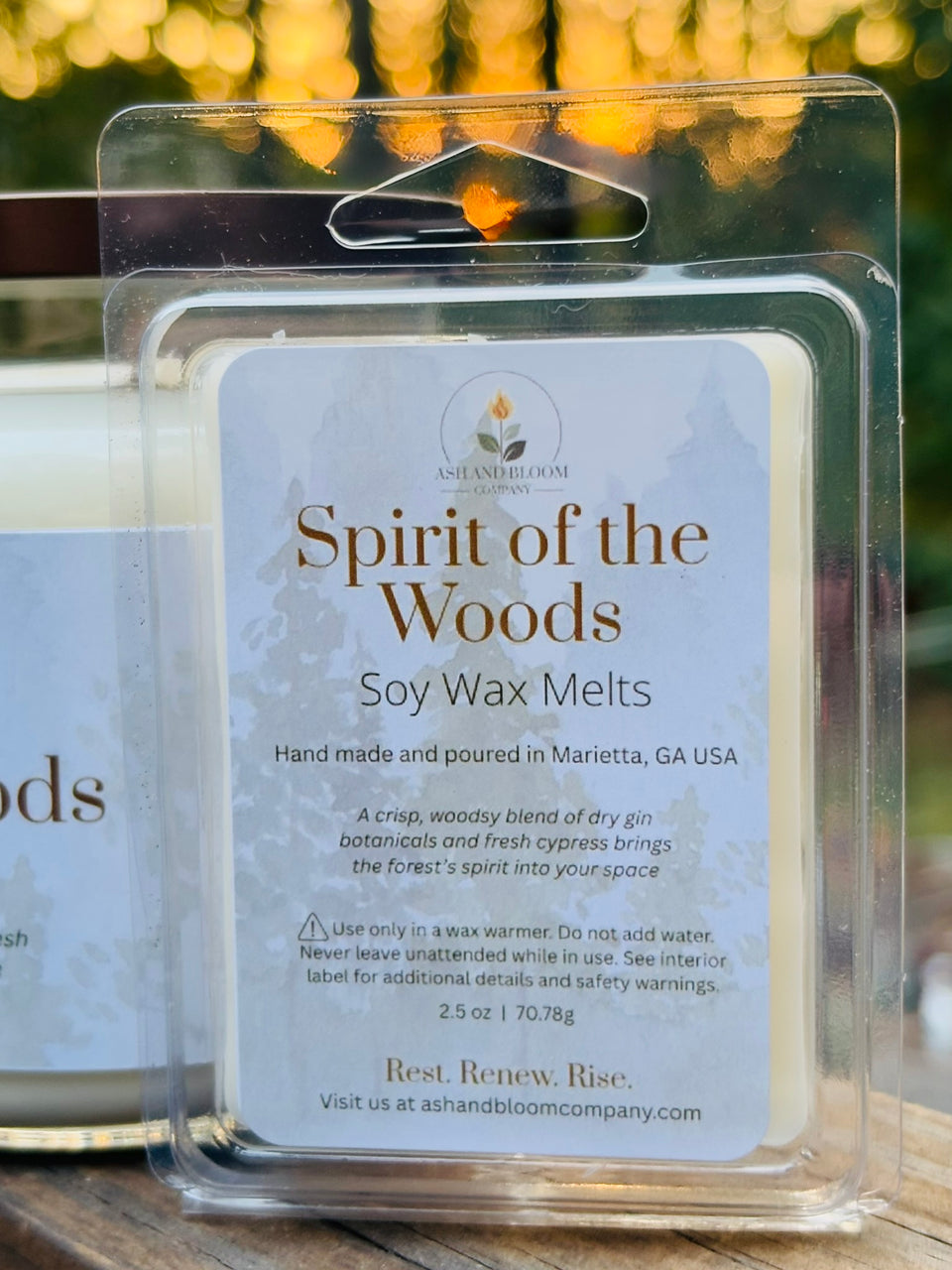Soy gin and cypress wax melts packaging labeled 'Spirit of the Woods' with a blurred outdoor background.
