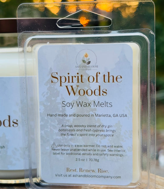 Soy gin and cypress wax melts packaging labeled 'Spirit of the Woods' with a blurred outdoor background.