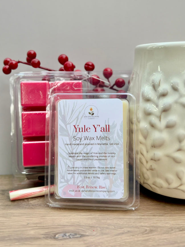 Peppermint and hot chocolate Yule Yall soy wax melts packaging with a candle and berries on a wooden surface