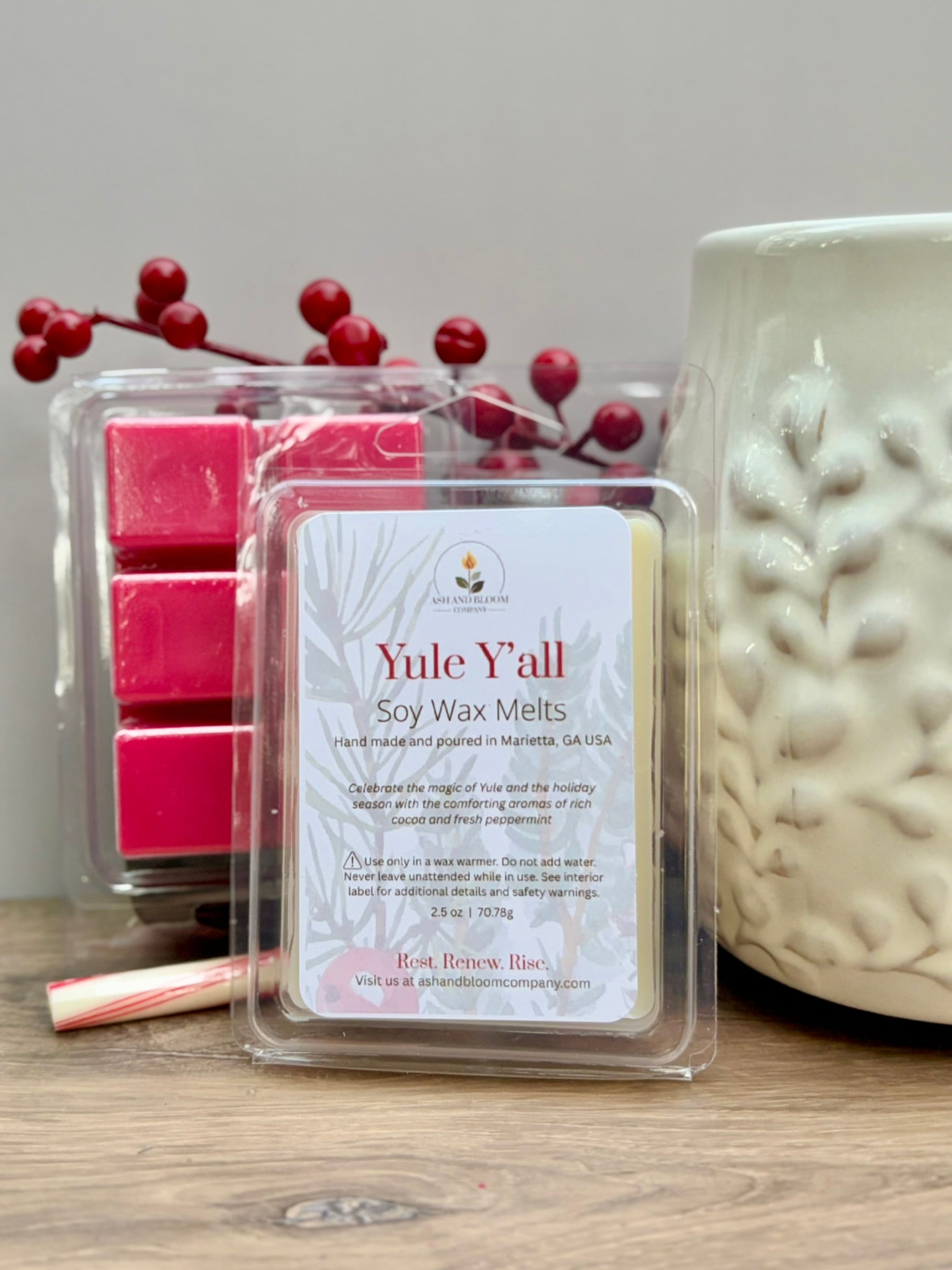 Peppermint and hot chocolate Yule Yall soy wax melts packaging with a candle and berries on a wooden surface
