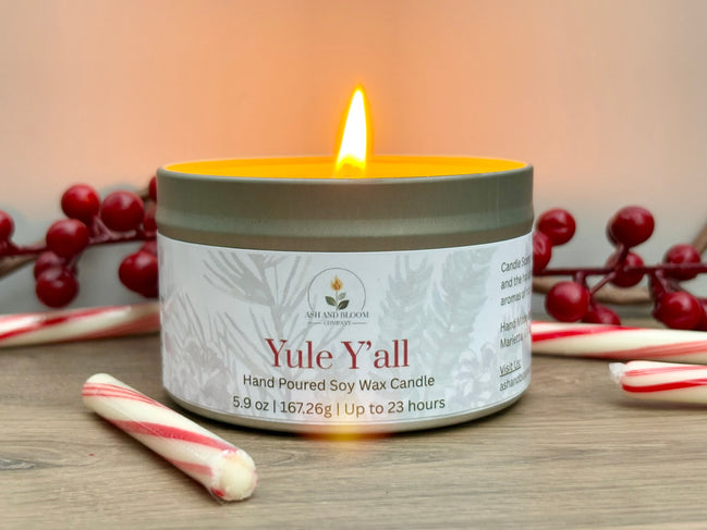 Peppermint and mocha candle labeled 'Yule Y'all' with festive elements on a wooden surface