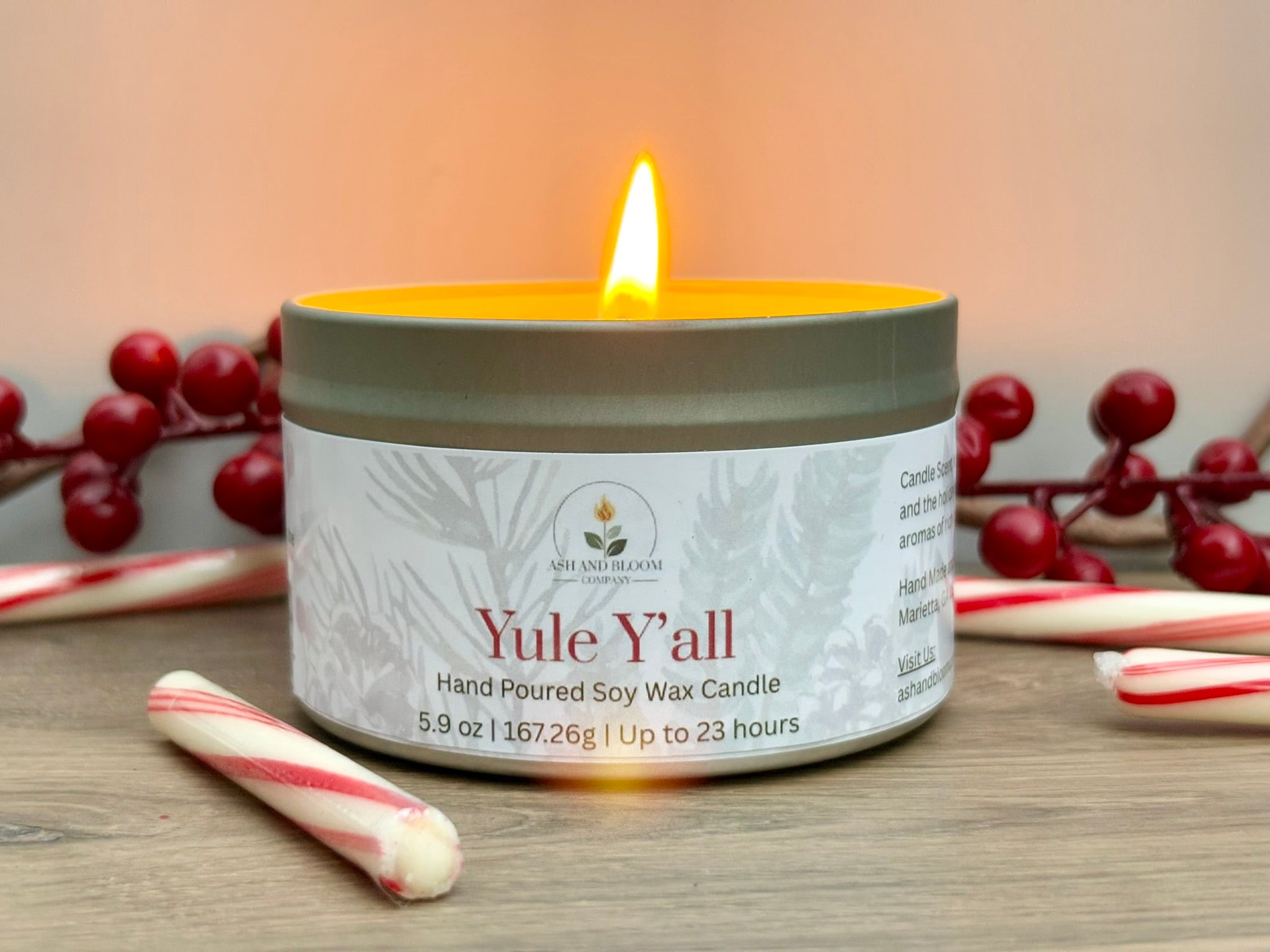 Peppermint and mocha candle labeled 'Yule Y'all' with festive elements on a wooden surface