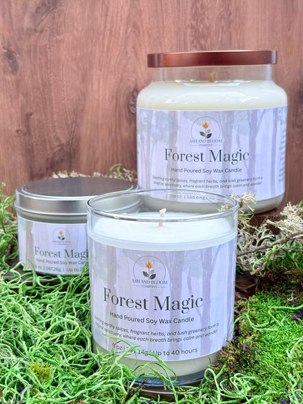 Three 'Forest Magic' candles on a wooden surface with grass.