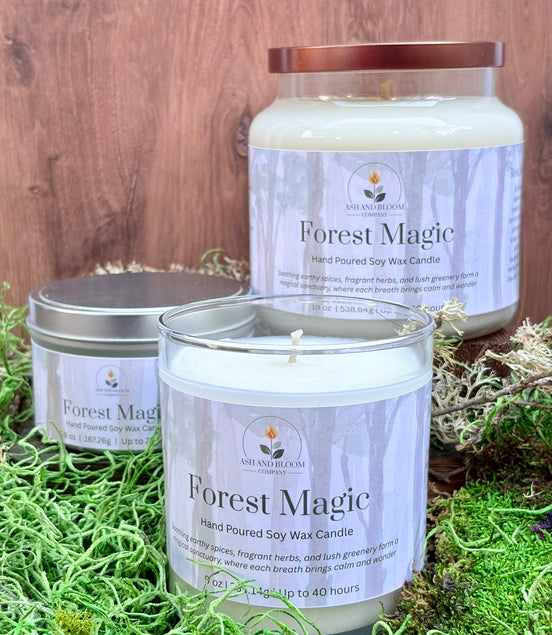 Three 'Forest Magic' candles on a wooden surface with grass.