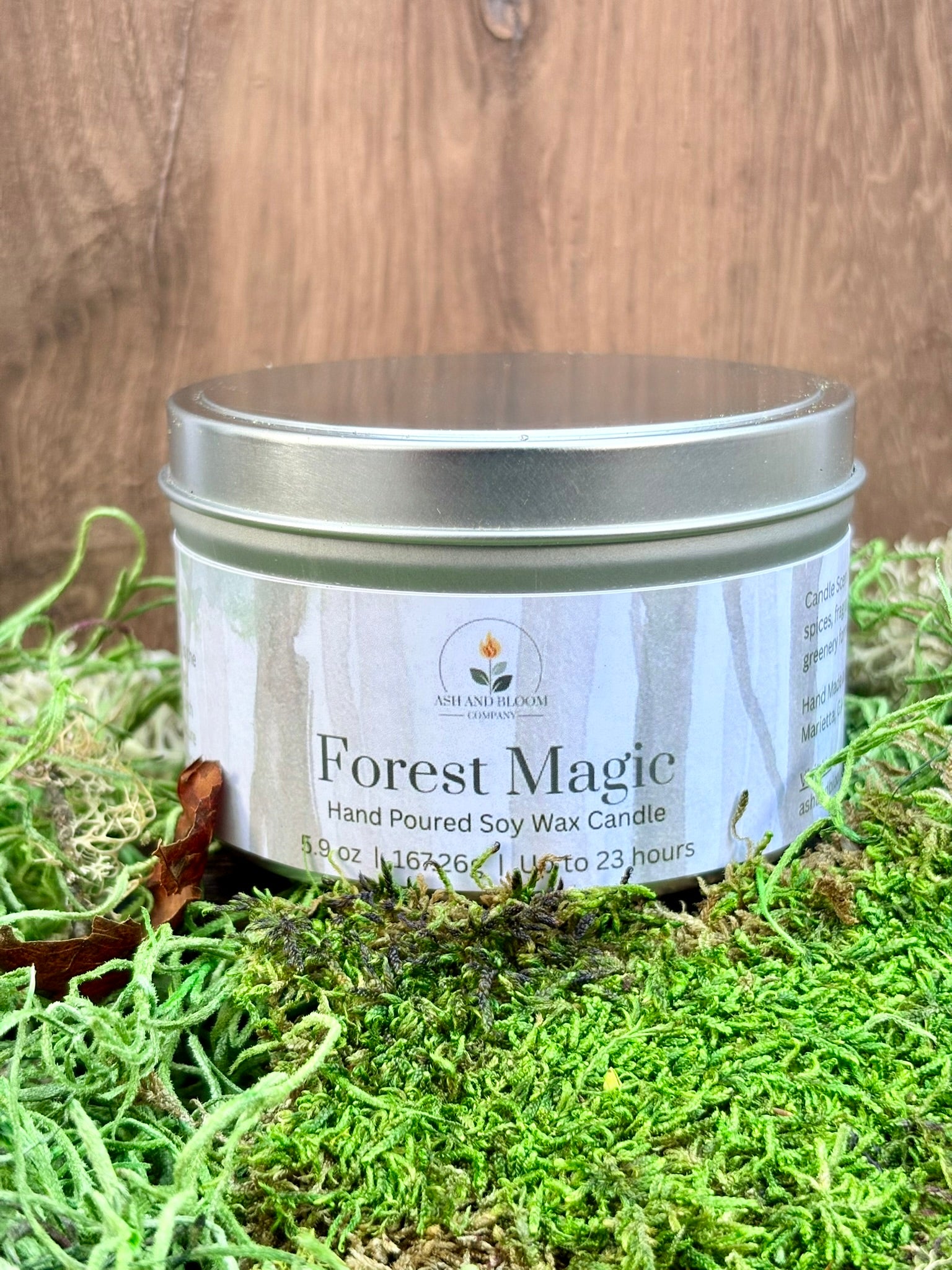 Candle jar labeled 'Forest Magic' on a grassy background