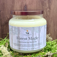 Candle jar labeled 'Forest Magic' on a wooden surface with grass.