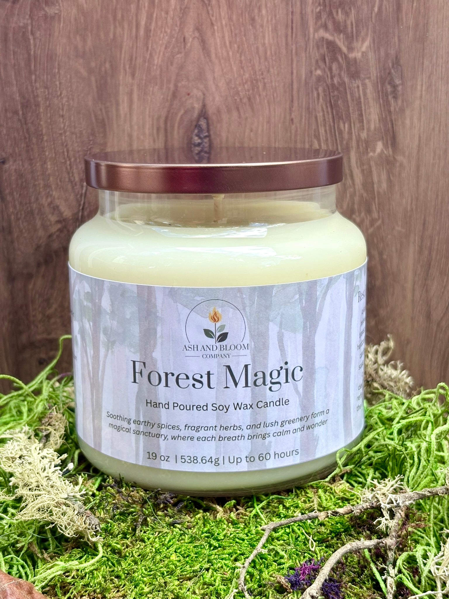 Candle jar labeled 'Forest Magic' on a wooden surface with grass.