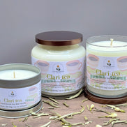 Three jasmine and white tea Clari Tea candles on a wooden surface with a gray background