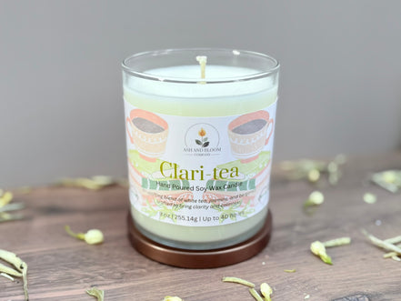 Candle labeled 'Clari-tea' on a wooden surface with a neutral background
