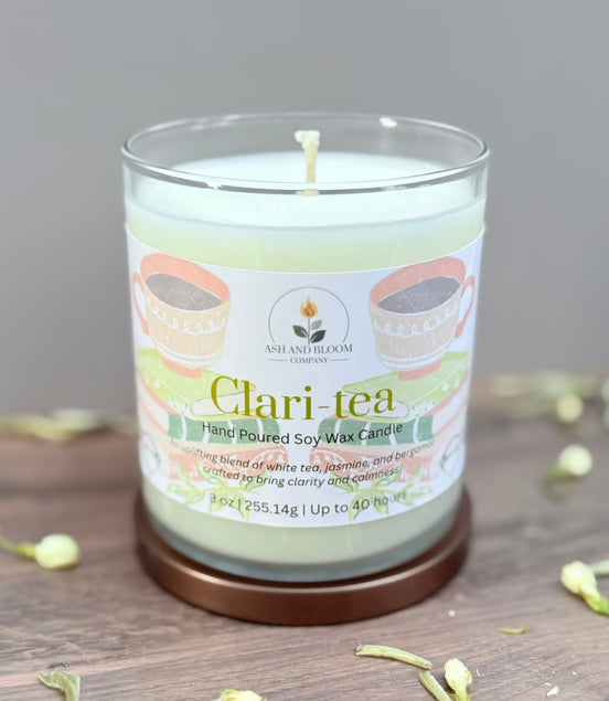 Candle labeled 'Clari-tea' on a wooden surface with a neutral background