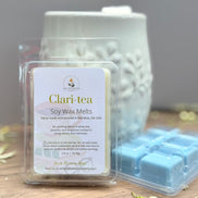 Clari-tea white tea and jasmine soy wax melts packaging on a wooden surface with a gray background