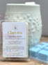 Clari-tea white tea and jasmine soy wax melts packaging on a wooden surface with a gray background