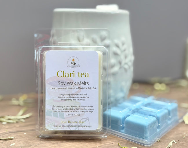 Clari-tea white tea and jasmine soy wax melts packaging on a wooden surface with a gray background