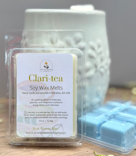 Clari-tea white tea and jasmine soy wax melts packaging on a wooden surface with a gray background