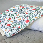 Floral-patterned cover on a white pillow on a gray surface