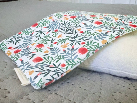 Floral-patterned cover on a white pillow on a gray surface