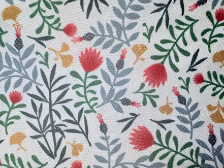 Patterned fabric with red, green, and yellow flowers on a white background