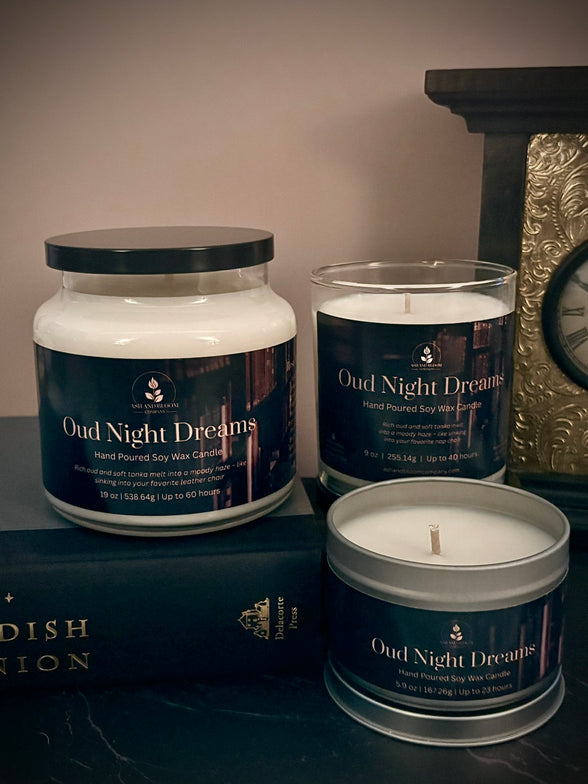 Three candles labeled 'Oud Night Dreams' on a dark surface with a decorative background.