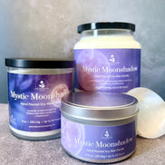 Three 'Mystic Moonshadow' candles of different sizes on a neutral background