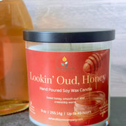 Hand poured soy wax candle labeled 'Lookin' Oud, Honey' on a neutral background