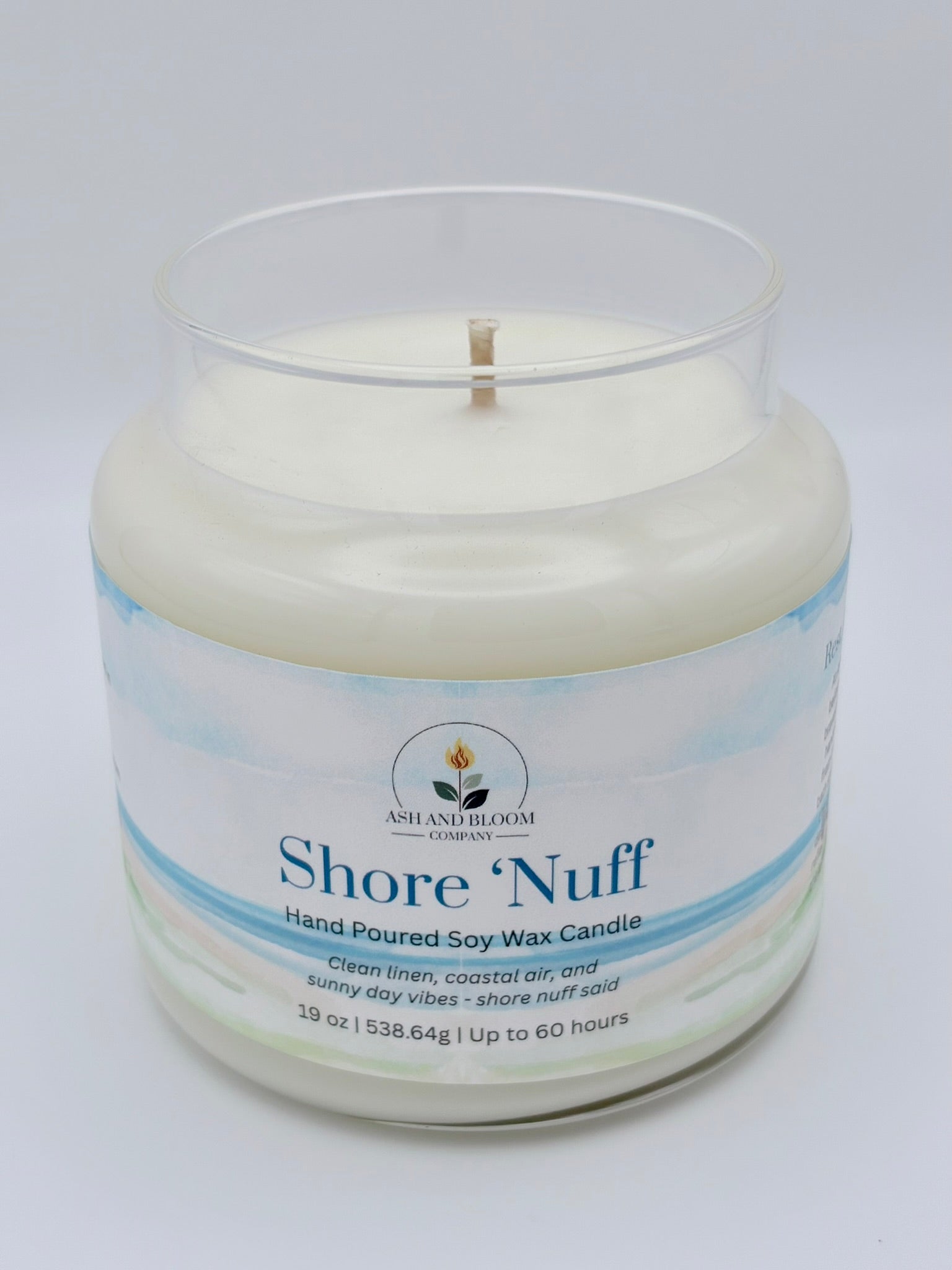 Candle in a glass jar with 'Shore 'Nuff' branding on a light gray background