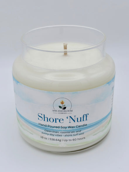 Candle in a glass jar with 'Shore 'Nuff' branding on a light gray background